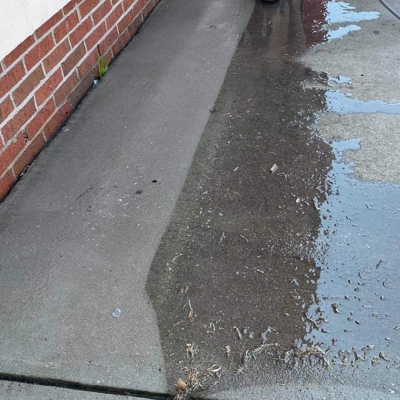 Concrete walkway being pressure cleaned