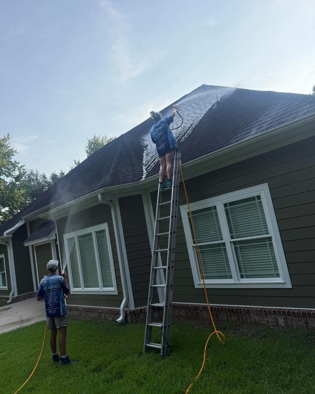 Power Suds crew soft washing a roof, black streaks lifting away